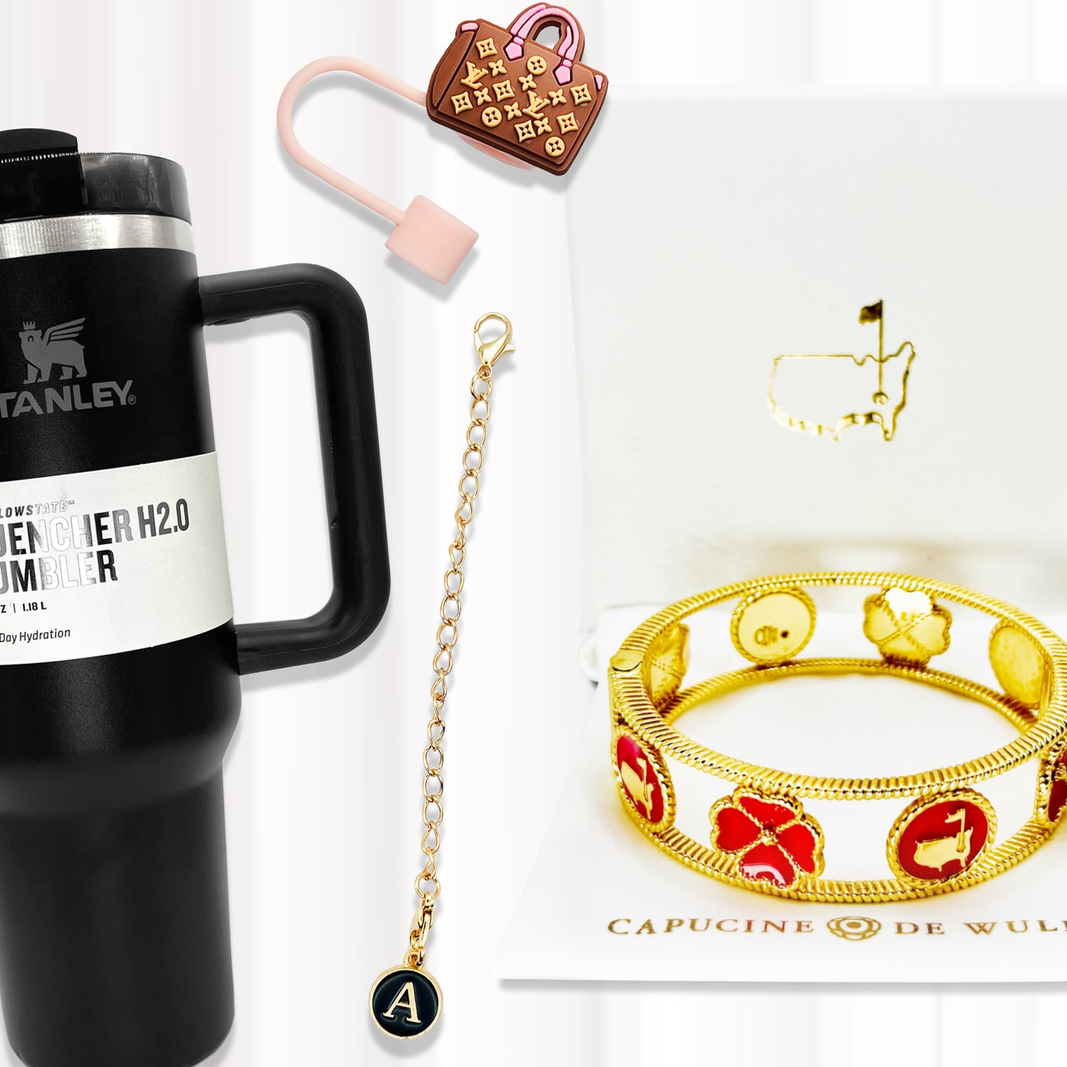 An image of a variety of items including a Stanley tumbler, Louis Vuitton straw topper, tumbler charm, and a Capucine De Wulf Dogwood bangle from the Augusta National Masters Collection.